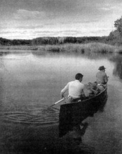 Black-and-white photograph of two people in a canoe