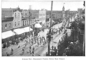 Black-and-white photograph of a parade on Main Street in Rat Portage.